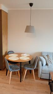a dining room with a table and chairs and a couch at Apartament Skarbowa East in Leszno +14 photos