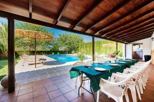 a dining room with a table and chairs and a pool at Alojamiento turístico Loma Alta in Cambil
