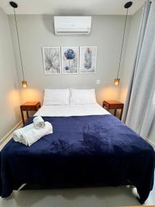 a bedroom with a large bed with a blue blanket at Recanto Serra e Mar in Angra dos Reis