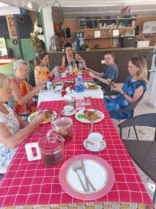 a group of people sitting around a table eating food at Maria's place in Tujering