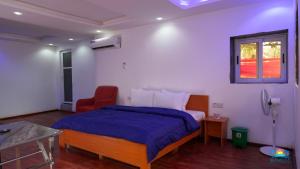 a bedroom with a bed and a red chair at SunRise Beach Resort in Iberekodo