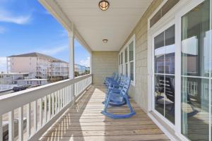 a porch with blue chairs on a house at Anchor Down Luxury Ocean View Beach House w Pool in Myrtle Beach +42 photos