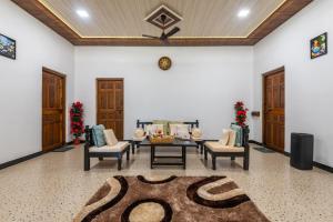 a living room with chairs and a table and a rug at Cabanas Retreat in Revadanda