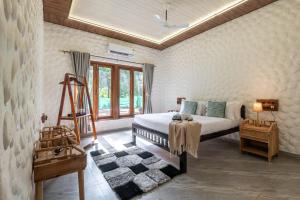 a bedroom with a bed and a window at Cabanas Retreat in Revadanda