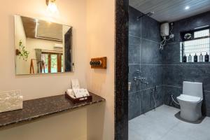 a bathroom with a shower and a toilet and a sink at Cabanas Retreat in Revadanda +17 photos