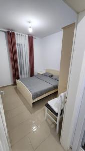 a bedroom with a bed and a chair in it at Diamond Apartment Vlore in Vlorë +18 photos
