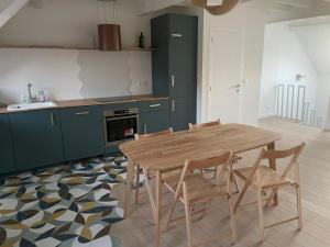 a kitchen with a wooden table and chairs at Triplex de charme avec vue in Brussels