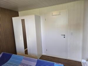 a bedroom with a white door and a blue bed at Sandra Fewo nähe Rømø in Bredebro in Bredebro