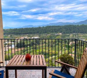a wooden table and chairs on a balcony with a view at Les Casetes in La Senia