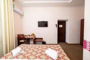 a bedroom with a bed and a table and a television at Caravan Boutique Ichan Kala in Khiva
