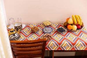 a table with a bowl of fruit and other foods on it at Caravan Boutique Ichan Kala in Khiva +89 photos