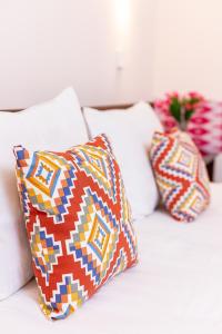 three pillows sitting on a white couch at Caravan Boutique Ichan Kala in Khiva