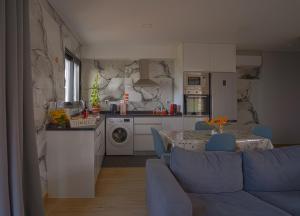 a kitchen and living room with a blue couch and a table at Moonfall House in Arco da Calheta