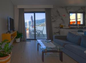 a living room with a couch and a table at Moonfall House in Arco da Calheta