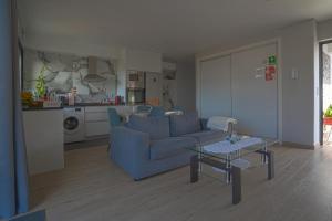 a living room with a blue couch and a table at Moonfall House in Arco da Calheta +32 photos