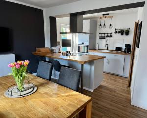 a kitchen with a table with a vase of flowers on it at stylisches Ferienhäuschen in Güstrow