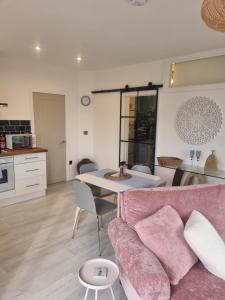 a living room with a pink couch and a table at Halwyn View in St Austell