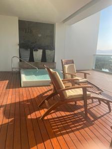 a bedroom with two rocking chairs and a bed at Gran Luxxe 2 bdrm suite in Nuevo Nayarit +10 photos