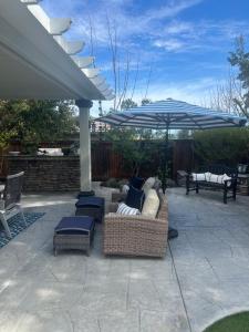 a patio with a couch and an umbrella and chairs at Gran Luxxe 2 bdrm suite in Nuevo Nayarit
