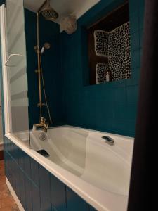 a bath tub in a bathroom with blue tiles at Dupplex, centre ville in Blois