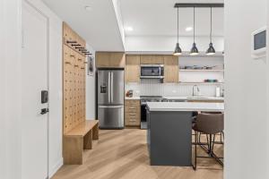 a kitchen with stainless steel appliances and wooden cabinets at Modern mountain luxury with stunning views in Canmore
