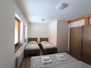 a room with two beds with towels on them at Horský apartmán U Čerťáka in Horní Václavov
