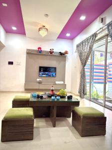 a living room with purple ceilings and a table and stools at SilverOak 4bhk Villa in Jāmb