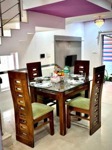 a dining room table with chairs and a table with food on it at SilverOak 4bhk Villa in Jāmb