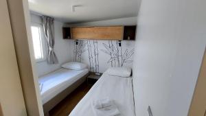 a small room with two beds and a window at Mobile home 249 - Large Terrace & Private Jacuzzi in Selce