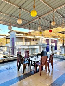 a patio with a table and chairs and lights at SilverOak 4bhk Villa in Jāmb