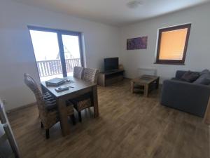 a living room with a table and a couch at Horský apartmán U Čerťáka in Horní Václavov