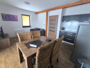 a dining table and chairs in a living room at Horský apartmán U Čerťáka in Horní Václavov