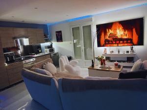 a living room with a blue couch and a fireplace at Maison cocooning , avec double jacuzzi et piscine in La Machine