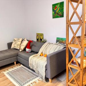 a living room with a gray couch and a ladder at Ferienwohnung Meerane Zentrum in Meerane