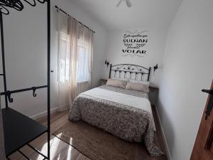 a bedroom with a bed in a white room at El Capricho de Nunu SIMANCAS in Simancas