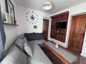 a living room with a couch and a clock on the wall at El Capricho de Nunu SIMANCAS in Simancas