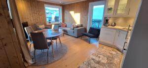 a kitchen and a living room with a table and chairs at Sentral leilighet på Geilo in Geilo