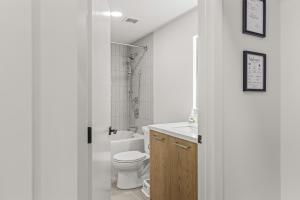 a white bathroom with a toilet and a sink at Modern mountain luxury with stunning views in Canmore +28 photos