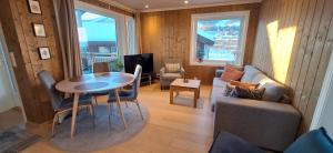 a living room with a table and a couch at Sentral leilighet på Geilo in Geilo