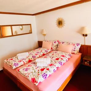 a bedroom with a bed with a floral bedspread at Adelhome Studio mit Gartensitzplatz in Adelboden