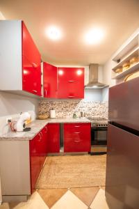 a kitchen with red cabinets and a stainless steel refrigerator at Patricia Apartments in Vilnius