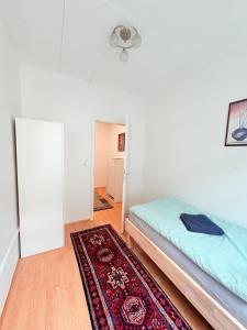 a bedroom with a bed and a rug at Beenie 18 in Linz