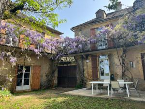 a house with purple wisteria on the side of it at Proche de SARLAT -Vue exceptionnelle in Carlux