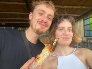 a man and a woman holding a corn cob at Sunscape lodge in Fort Portal