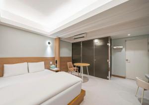 a bedroom with a bed and a desk and a table at 9AVENUE hotel in Daegu
