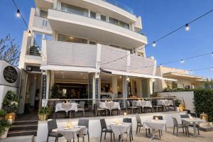 a restaurant with tables and chairs in front of a building at Nauticus Hotel Ugento in Torre San Giovanni Ugento