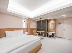 a hotel room with a bed and a desk at 9AVENUE hotel in Daegu