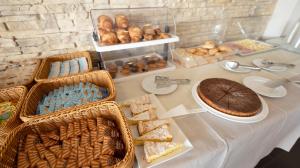a table topped with baskets and a cake and pastries at Nauticus Hotel Ugento in Torre San Giovanni Ugento +24 photos