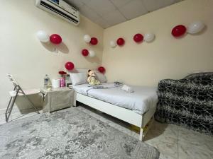 ein Zimmer mit einem Bett und Luftballons an der Wand in der Unterkunft Harmony House in Al Muwayqi‘ī