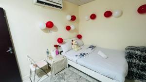 ein Zimmer mit einem Bett und roten Luftballons an der Wand in der Unterkunft Harmony House in Al Muwayqi‘ī